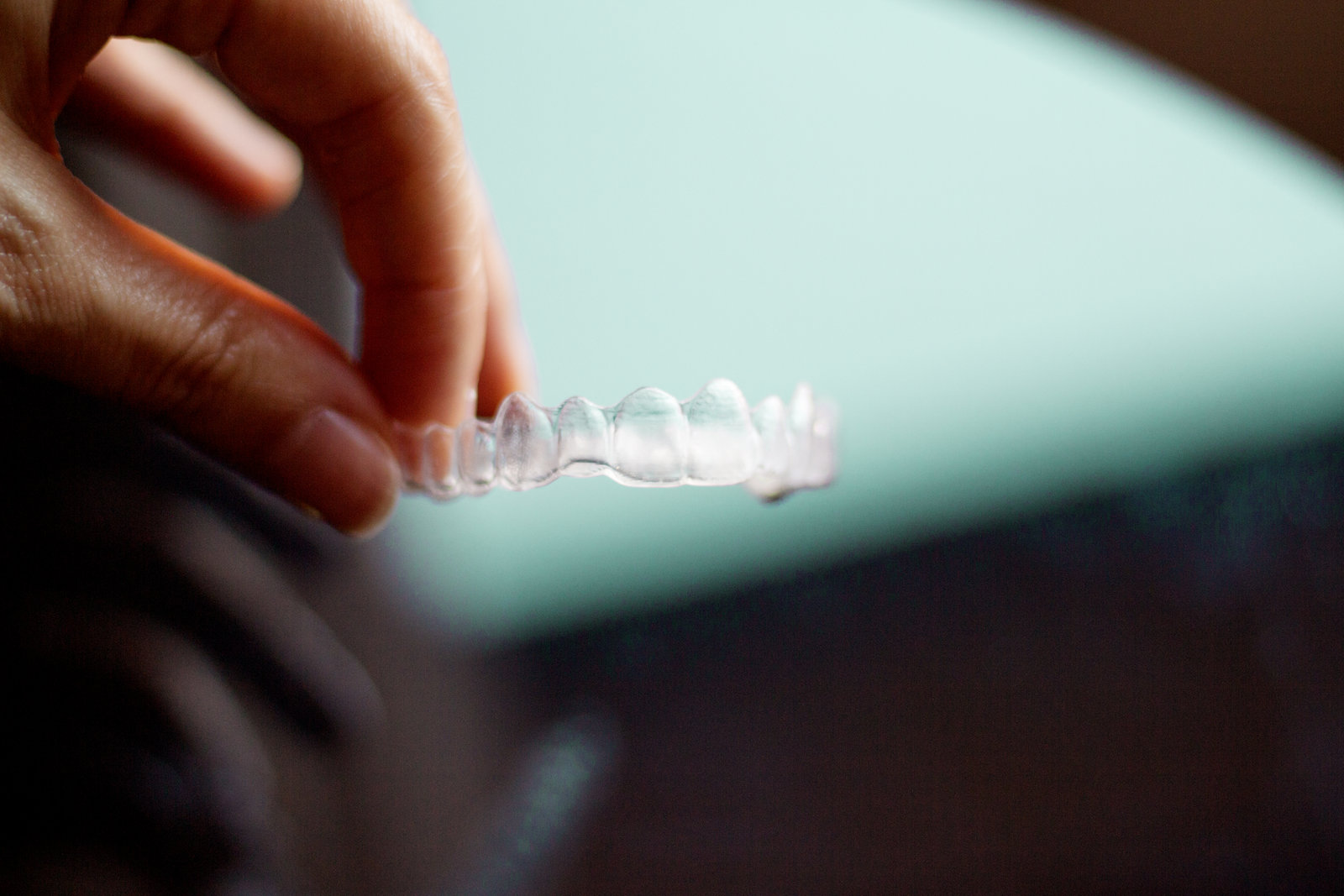 Hand holding a transparent NEXO aligner